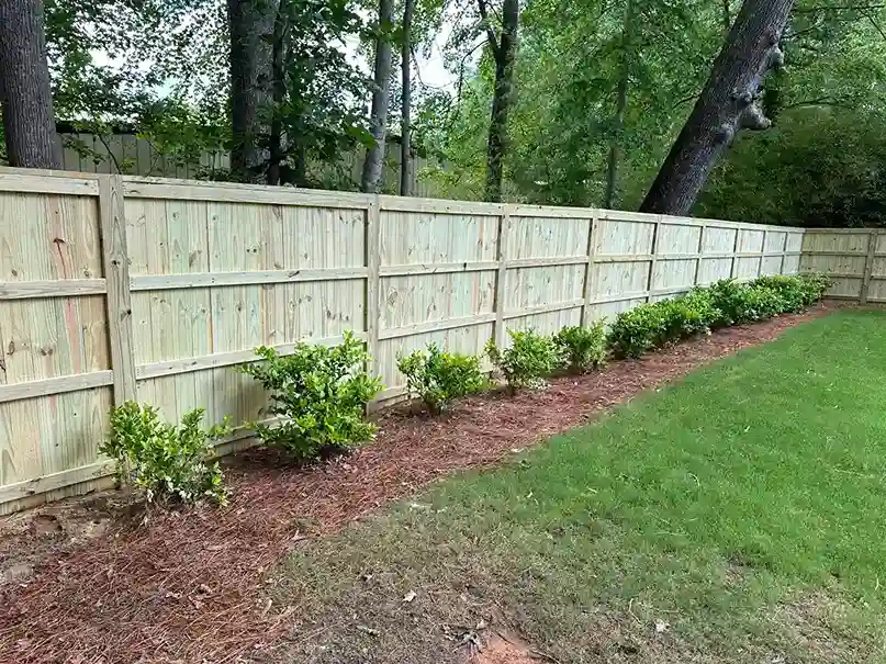 Wood privacy fence along a landscaped backyard